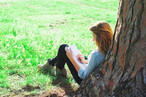 woman writing under a tree woman writing under a tree